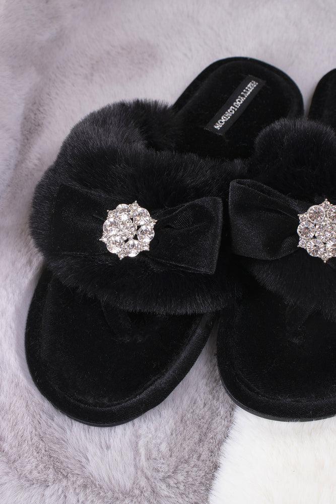 
                  
                    Amelie women's toe post slippers in black with a premium velvet bow and diamante embellishment atop a plush faux fur band from Pretty You London
                  
                