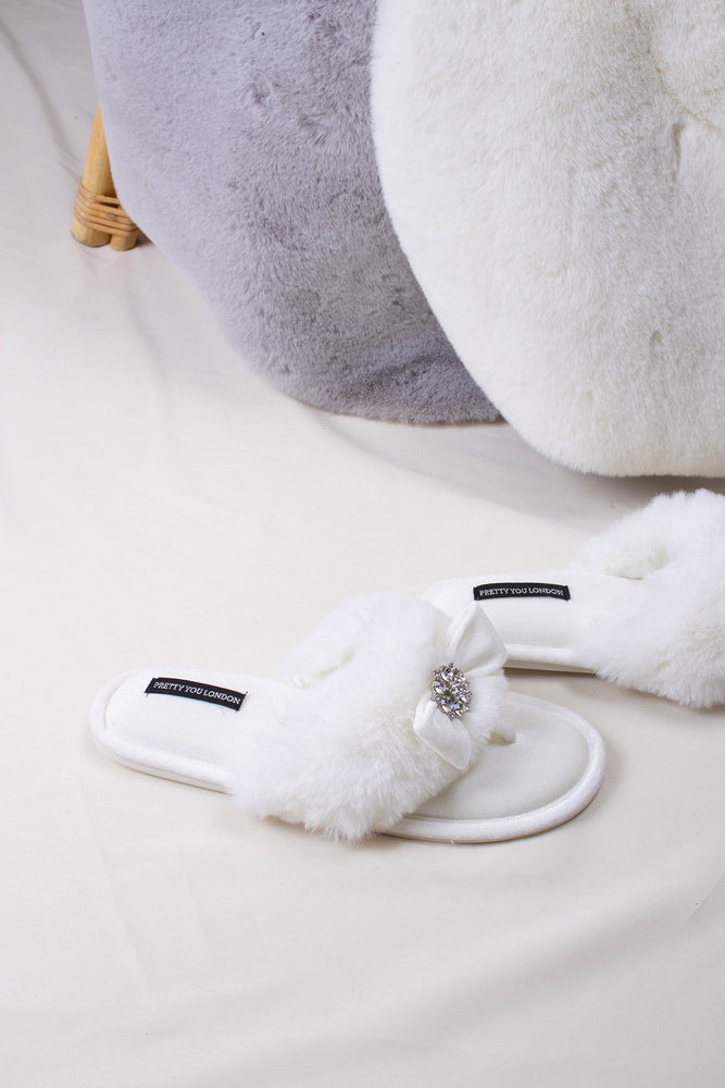
                  
                    Amelie women's toe post slippers in cream with a premium velvet bow and diamante embellishment atop a plush faux fur band from Pretty You London
                  
                