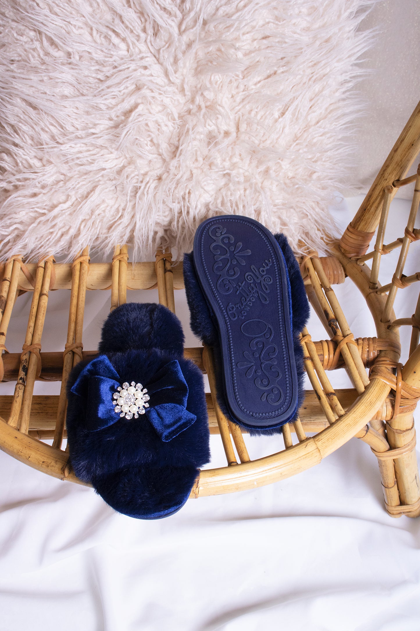
                  
                    Anya women's slider slippers in navy using the softest faux furs and topped with a premium grosgrain bow finished with a jewel pearl embellishment from Pretty You London
                  
                
