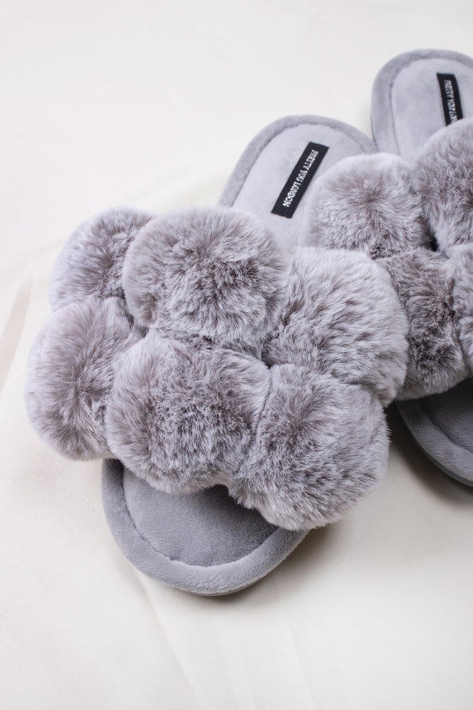 
                  
                    Dolly women's slider slippers in grey with oversized faux fur pom poms from Pretty You London
                  
                